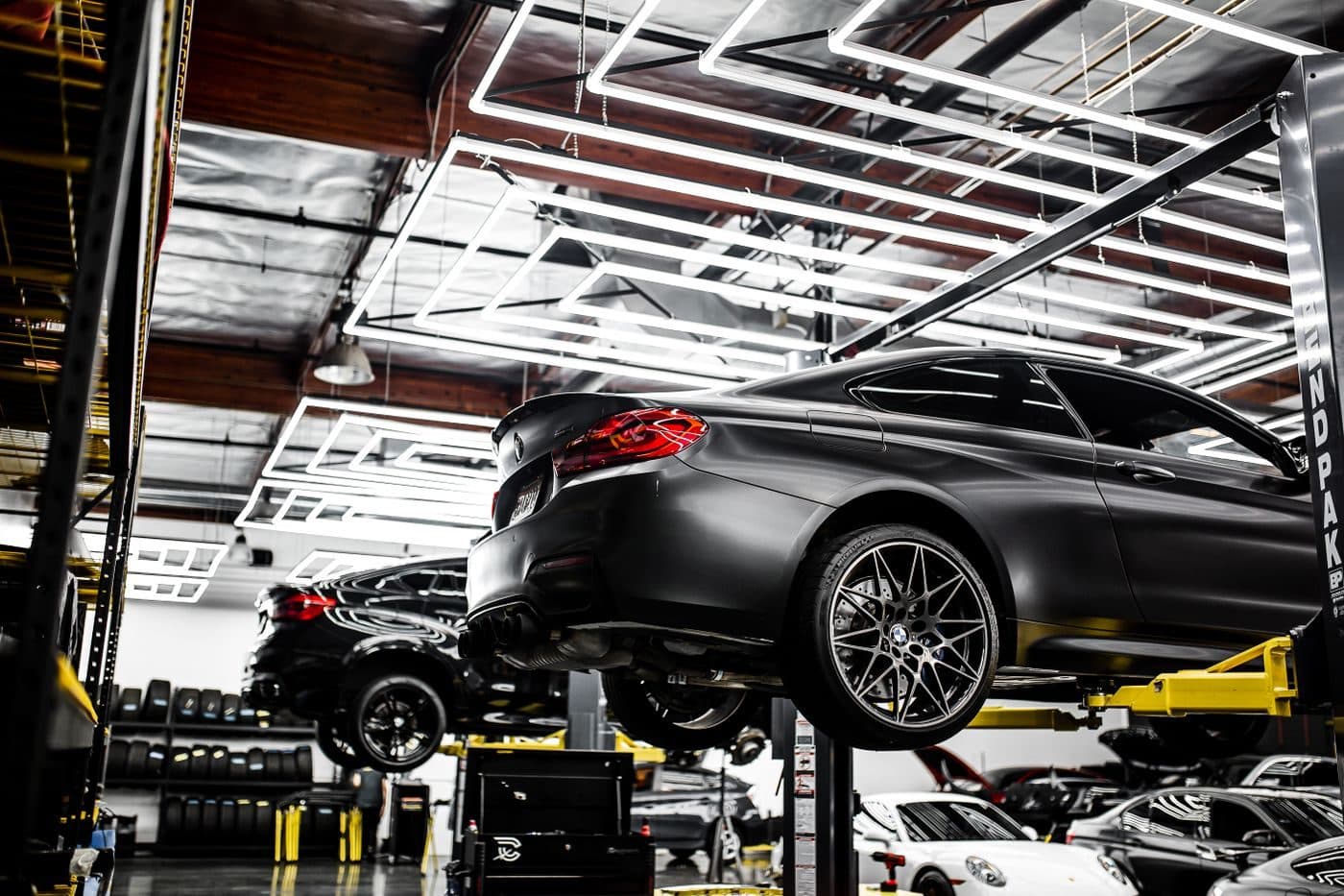Vehicles raised on two-post lifts in the workshop